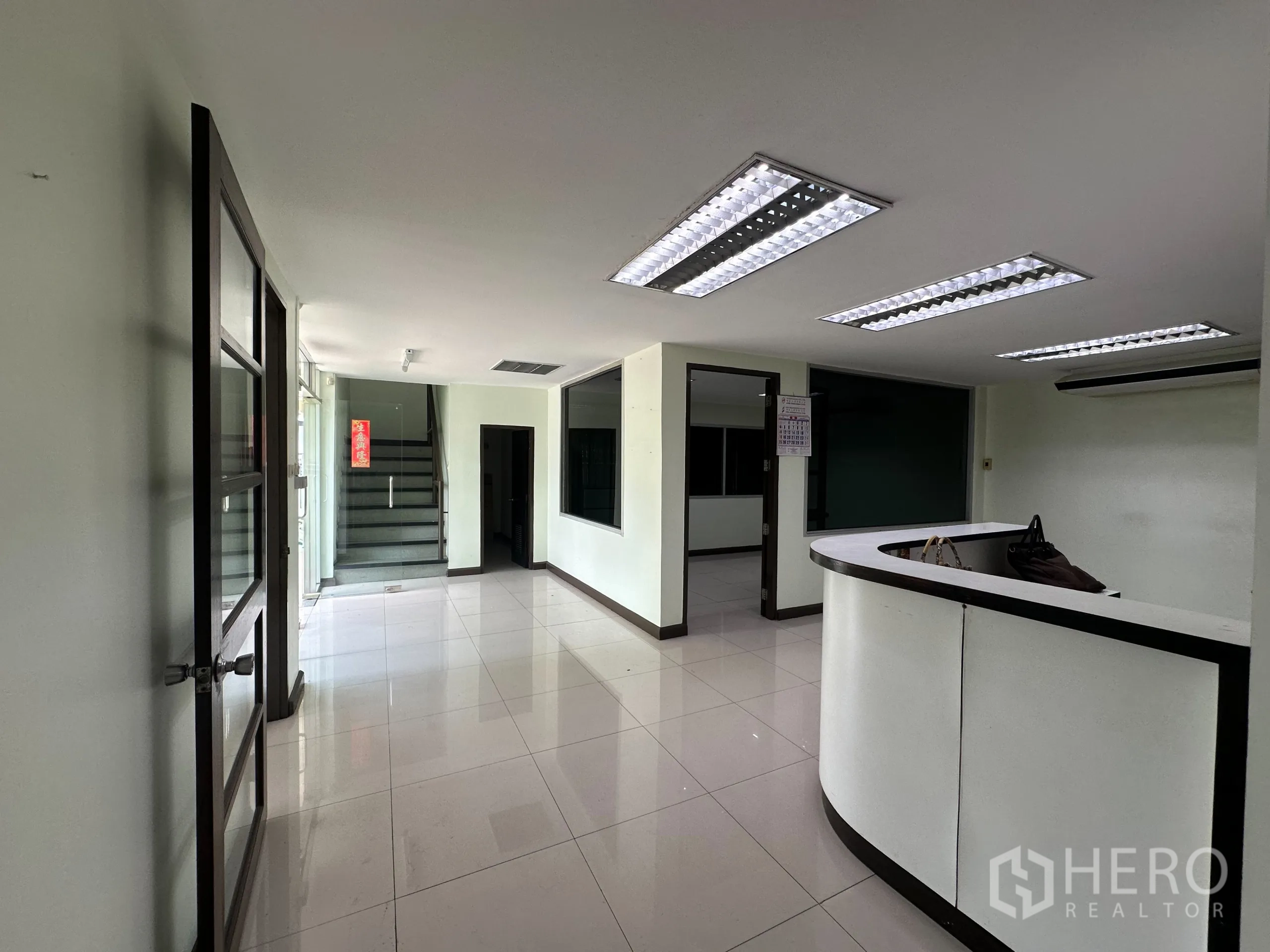 零售空间 出租在Watthana, Bangkok - 一层接待区，弧形前台与通往二层的楼梯。