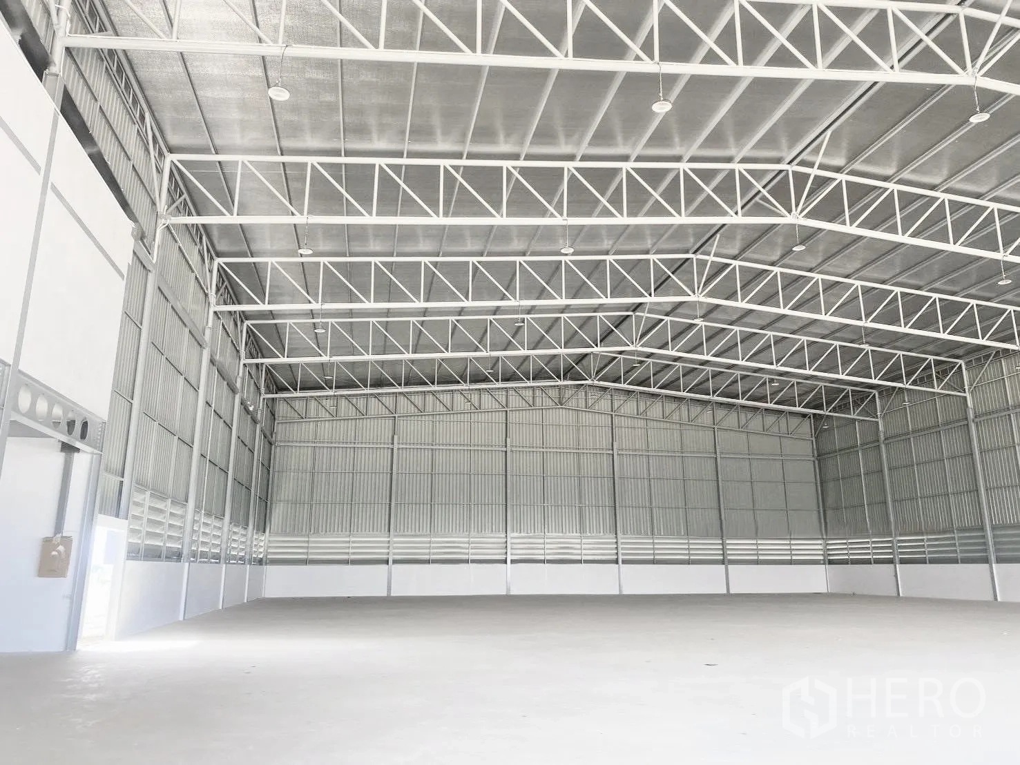 Warehouse for rent in Bang Bo, Samut Prakan - Wide warehouse bay showing metal roof structure and evenly spaced ceiling lights.