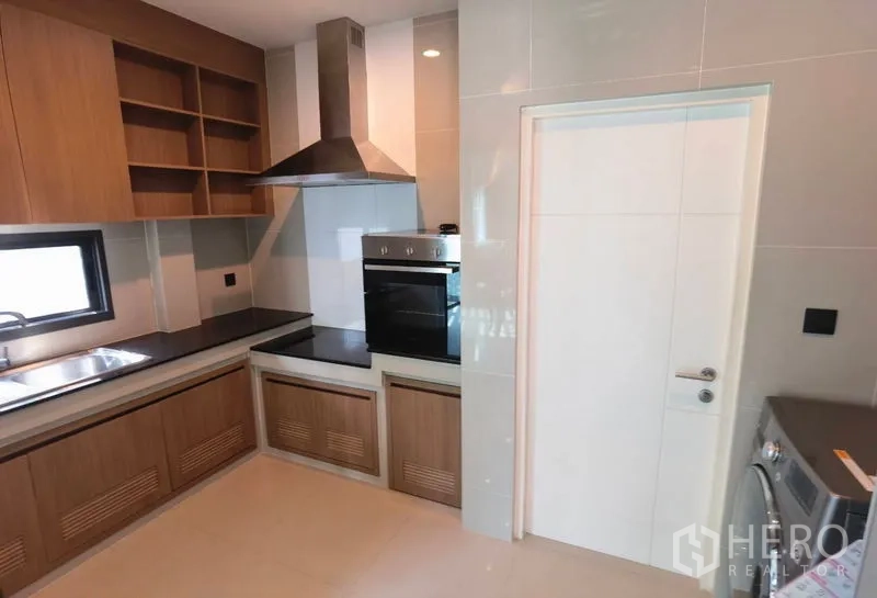 บ้าน ให้เช่าในBang Kapi, Bangkok - ห้องครัวบิวต์อินพร้อมตู้เก็บของ เคาน์เตอร์หิน เตาอบ เตา และเครื่องดูดควันสเตนเลส