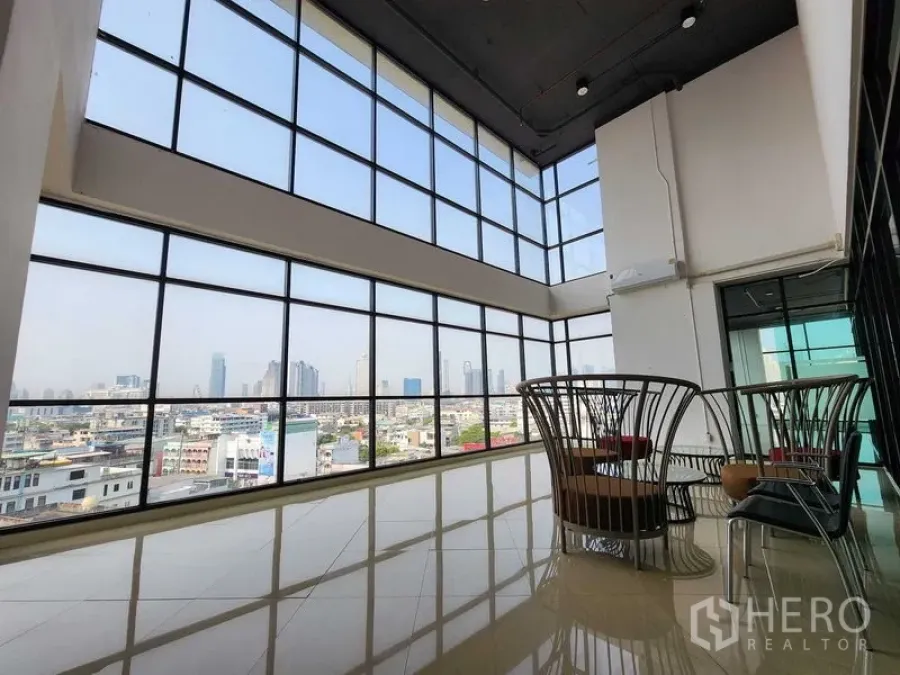 Office Space for rent in Yan Nawa, Bangkok - Double-height corner office lounge with floor-to-ceiling windows and Bangkok skyline view.