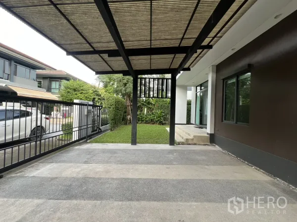 บ้าน ให้เช่าในBang Kapi, Bangkok - มุมมองจากโรงจอดรถไปยังถนน พร้อมประตูรั้วและสวนเล็ก