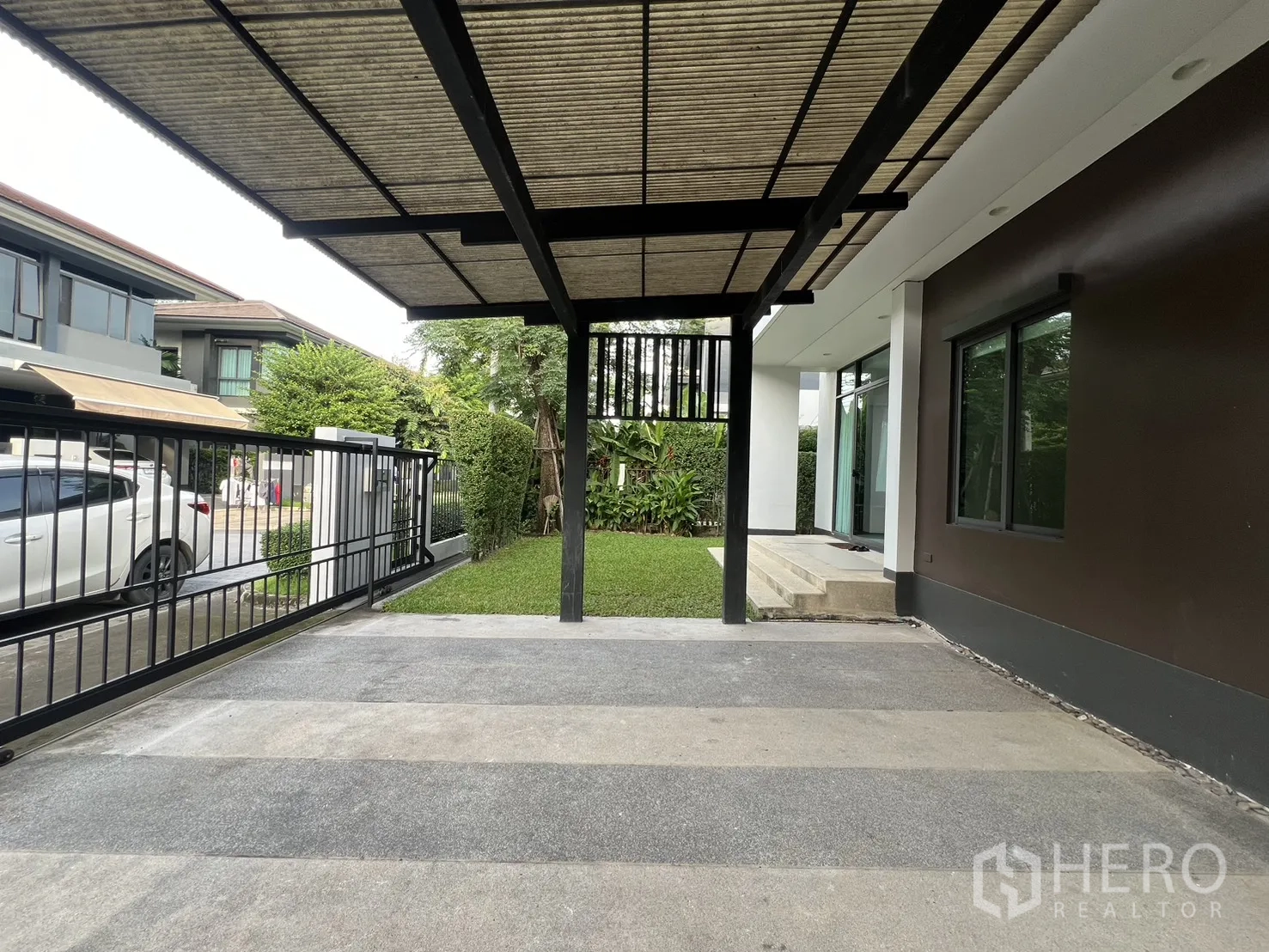 บ้าน ให้เช่าในBang Kapi, Bangkok - มุมมองจากโรงจอดรถไปยังถนน พร้อมประตูรั้วและสวนเล็ก