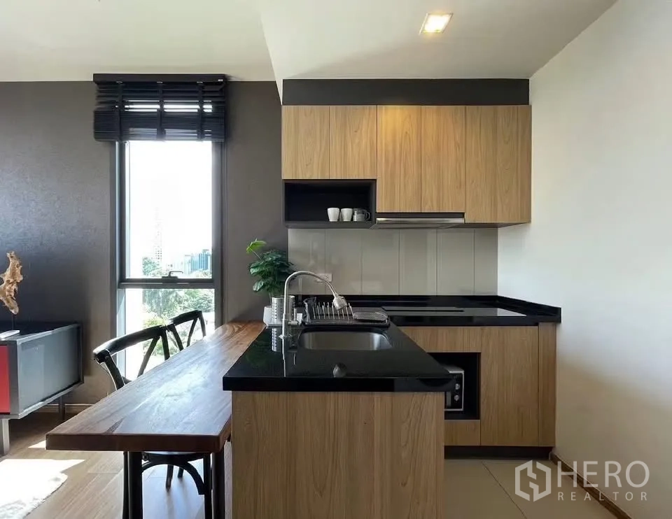 คอนโด for rent in Watthana, Bangkok - ครัวรูปตัวแอลเคาน์เตอร์หินสีดำและหน้าต่างรับแสงธรรมชาติ
