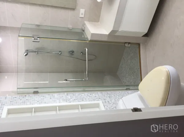 公寓 出租在Khlong Toei, Bangkok - 现代卫生间，玻璃淋浴间、手持花洒与洗手台。