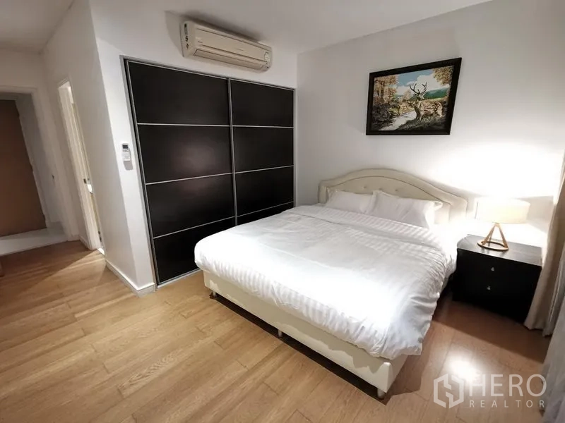 Condominium for rent in Watthana, Bangkok - Bright secondary bedroom with king bed, built-in wardrobe, and wood floors.