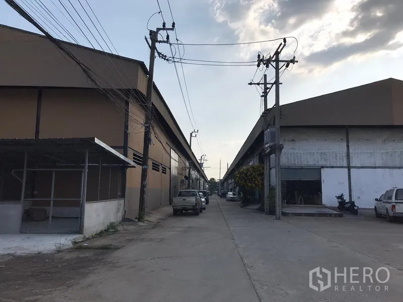 Warehouse for rent in Bang Phli, Samut Prakan - Internal access road between warehouse buildings with overhead power lines and truck-friendly concrete lane.
