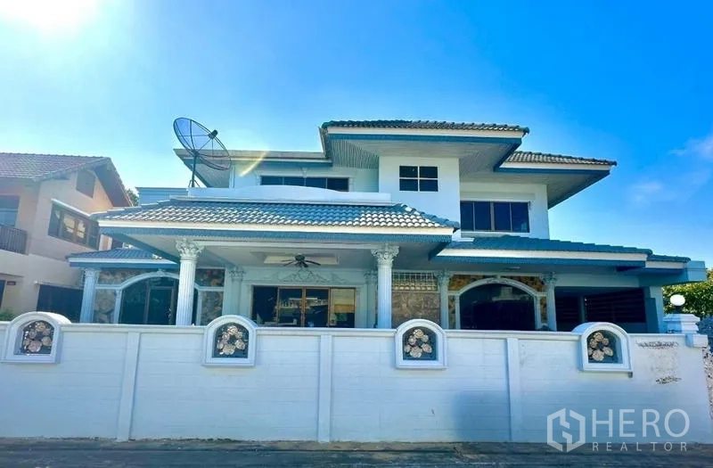 บ้าน ให้เช่าในTaling Chan, Bangkok - ด้านหน้าบ้านหลังรั้วสีขาว พร้อมเสาคลาสสิกและหน้าต่างโค้ง.