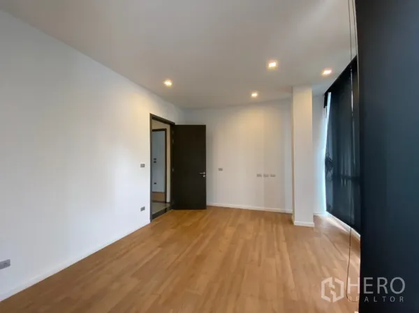 Home Office for rent or sale in Watthana, Bangkok - Bright empty office with timber flooring, recessed lighting, and dark window blinds.