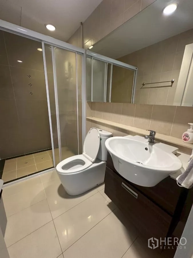 Townhouse for rent in Chom Thong, Bangkok - Bathroom featuring glass shower enclosure, vanity and toilet.