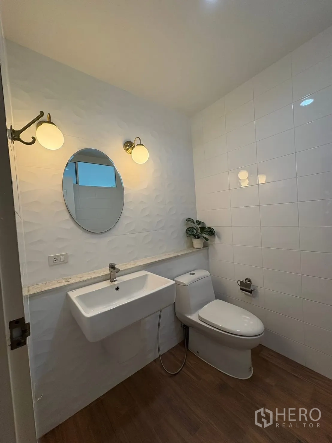 独栋房屋 for rent in Prawet, Bangkok - 一楼卫生间，台盆、坐便器与壁灯。