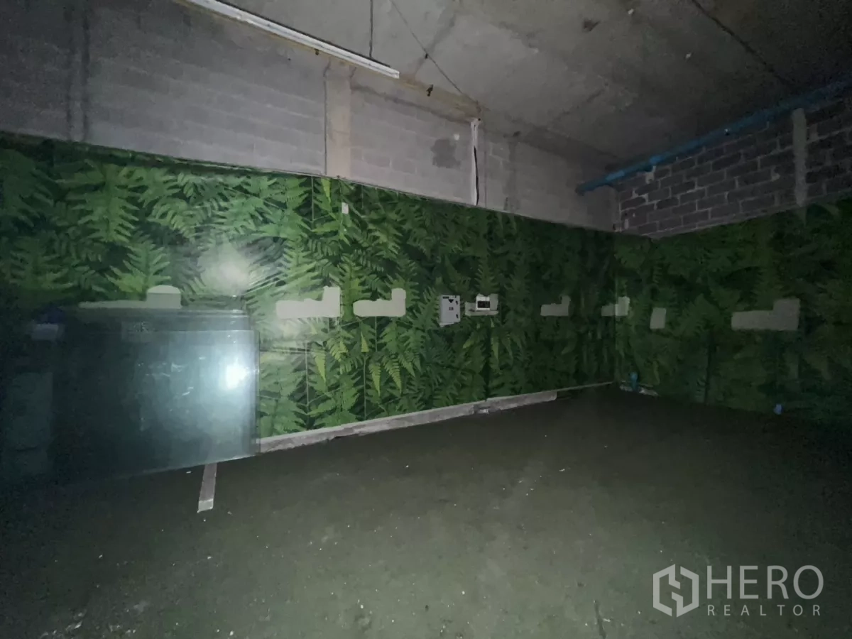 零售空间 出租 - 未配家具的商铺，蕨叶图案墙面、裸露天花与水泥地面。