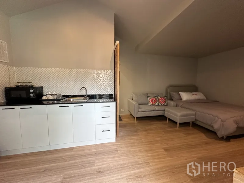 带办公室的家 出租在Suan Luang, Bangkok - 池畔一体式小公寓内景，含小厨房、沙发与床。