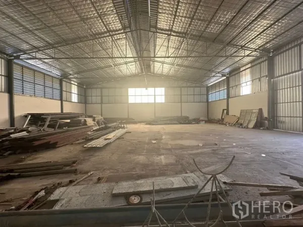 Warehouse for rent in Saphan Sung, Bangkok - Central view of empty warehouse with skylight windows, industrial lighting and clear concrete floor.