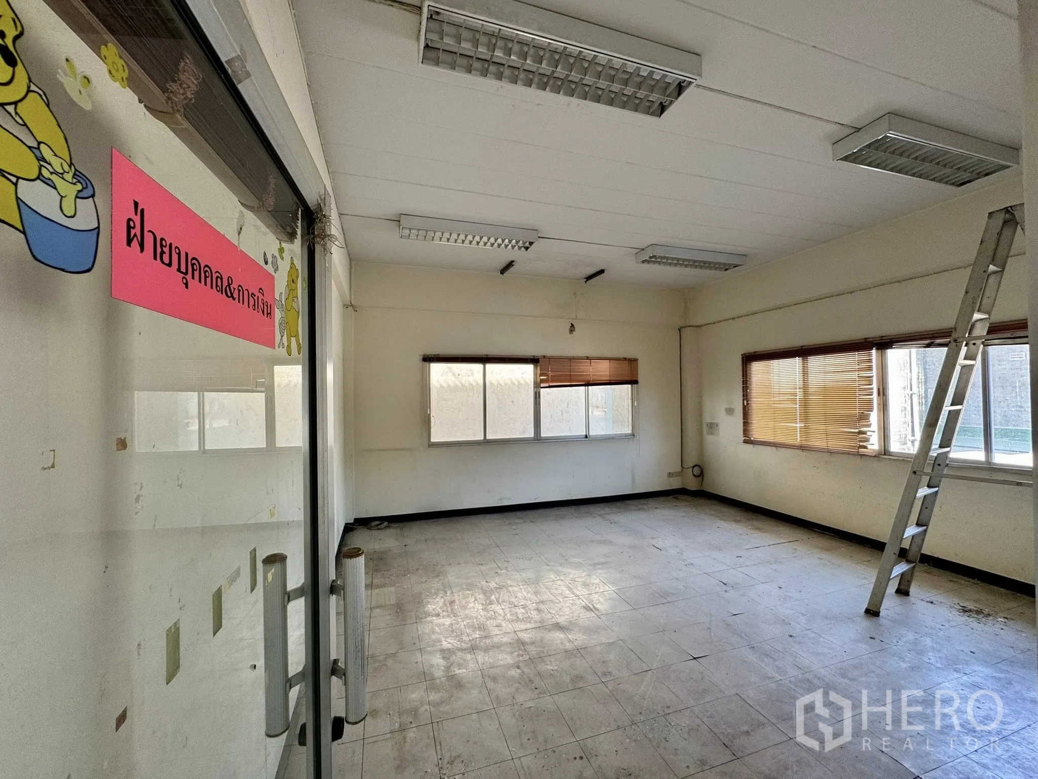 货栈 for rent in Mueang Samut Sakhon, Samut Sakhon - 玻璃门后的办公室，泰文标识，房内有梯子。