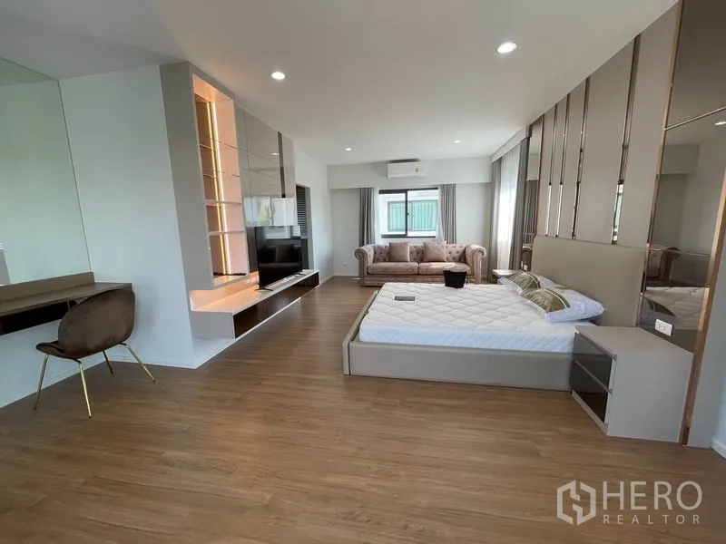 บ้าน ให้เช่าในPrawet, Bangkok - มุมห้องนอนมาสเตอร์แสดงผนังทีวี โซฟา และพื้นไม้