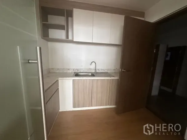 办公空间 出租在Bang Rak, Bangkok - 紧凑型茶水间，带水槽、石纹台面及上下收纳柜。