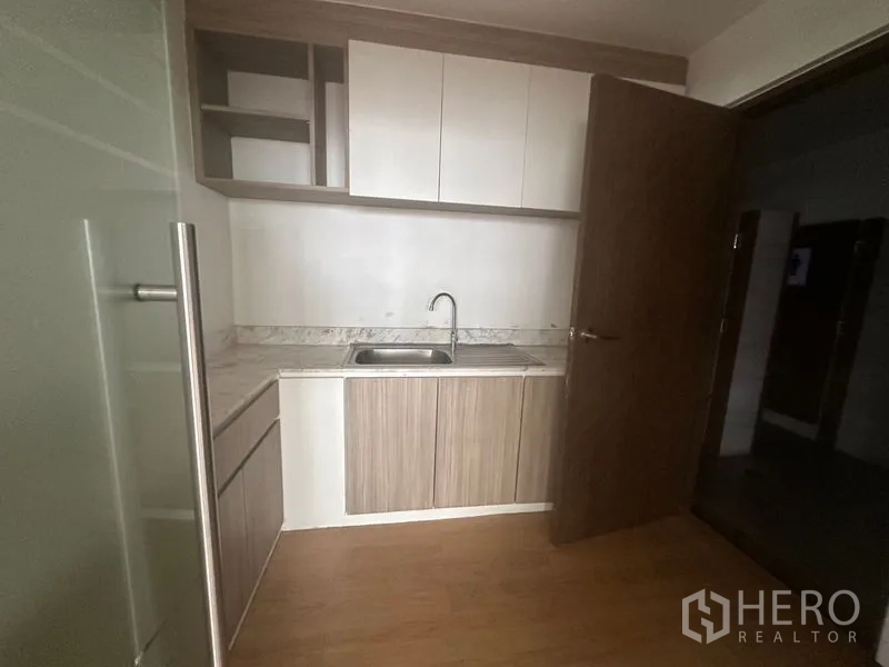 办公空间 出租在Bang Rak, Bangkok - 紧凑型茶水间，带水槽、石纹台面及上下收纳柜。