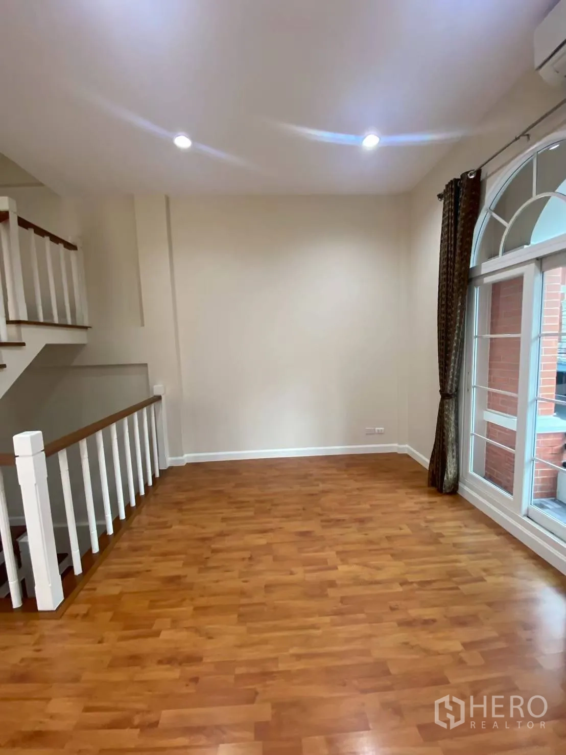Townhouse for rent in Bang Kapi, Bangkok - Mezzanine living space with railing and balcony doors.