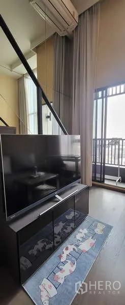 Condominium for rent - TV console facing large windows with sliding door leading to the balcony.