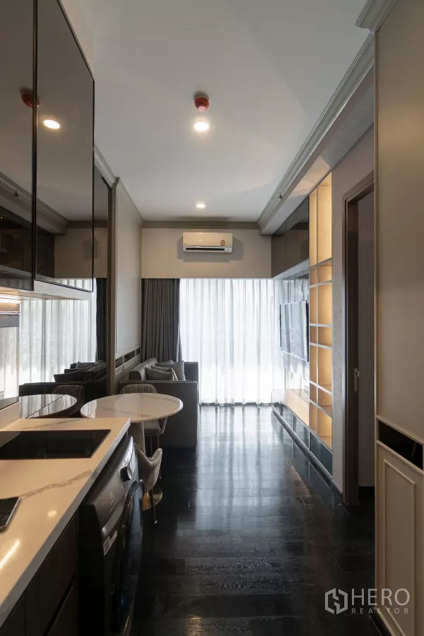 公寓 出租在Watthana, Bangkok - 从一字型厨房望向客厅，落地纱帘与空调。