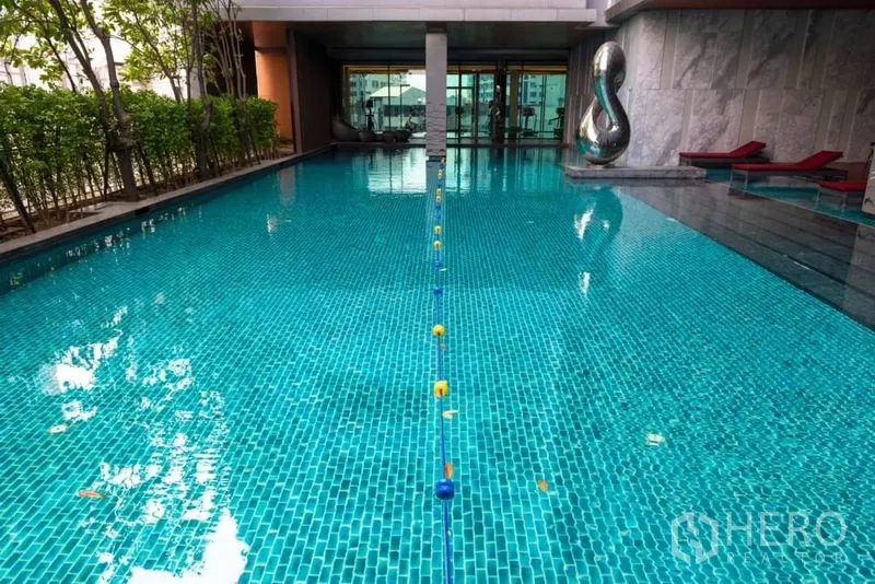 คอนโด ให้เช่าในWatthana, Bangkok - สระว่ายน้ำแบบสระซ้อมระยะในคอนโด พร้อมแนวต้นไม้และเตียงอาบแดด