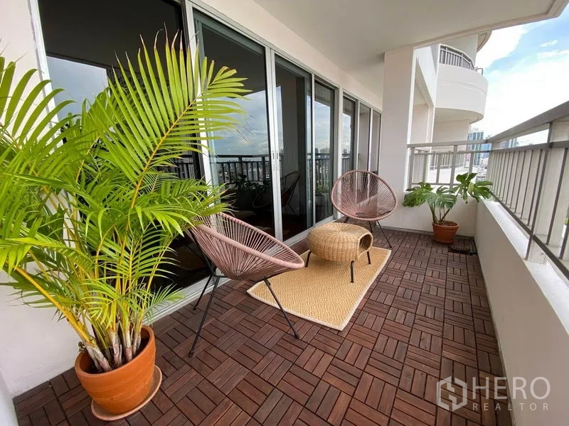 คอนโด ให้เช่าในSathon, Bangkok - อีกมุมของระเบียงที่มีเก้าอี้นั่งเล่น พรมกลางแจ้ง และต้นปาล์มกระถาง