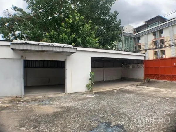 货栈 出租在Lak Si, Bangkok - 带顶停车或装卸棚，多个开放车位与红色围墙大门