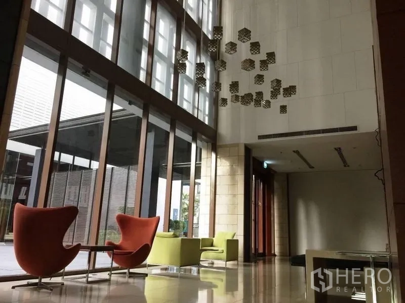 คอนโด ให้เช่าในKhlong Toei, Bangkok - ล็อบบี้คอนโดเพดานสูง ผนังกระจกเต็มบาน พร้อมเก้าอี้นั่งเล่นดีไซน์โมเดิร์น