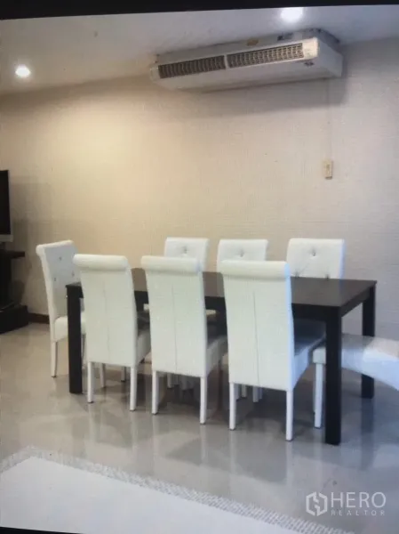 公寓 出租在Bang Rak, Bangkok - 餐区设深色餐桌与六把白色软包椅，上方为壁挂式空调。