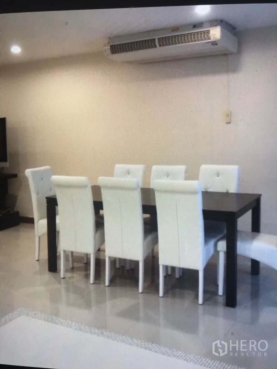 公寓 出租在Bang Rak, Bangkok - 餐区设深色餐桌与六把白色软包椅，上方为壁挂式空调。