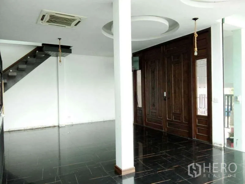 บ้าน ขายในLat Phrao, Bangkok - โถงทางเข้า พื้นกระเบื้องสีดำและประตูไม้บานคู่ลายคลาสสิก