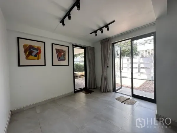 Home Office for rent in Watthana, Bangkok - Room with sliding glass doors to the patio, track lights and framed artwork.