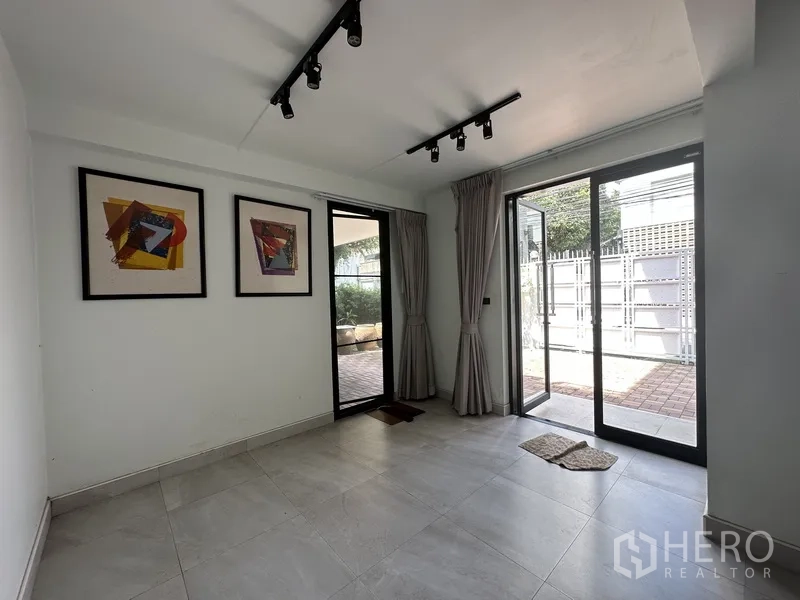 Home Office for rent in Watthana, Bangkok - Room with sliding glass doors to the patio, track lights and framed artwork.