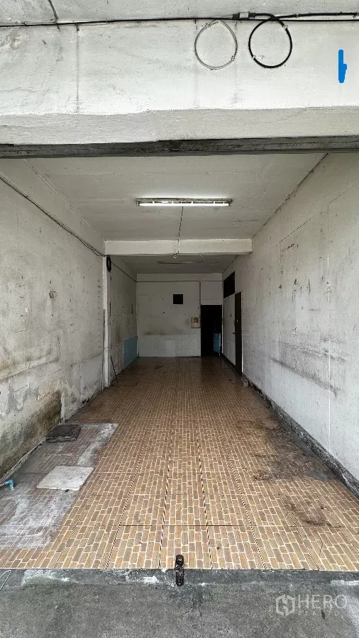 Shophouse for rent in Chatuchak, Bangkok - Ground-floor shophouse interior with long tiled floor, white walls and fluorescent lighting, ready for renovation.