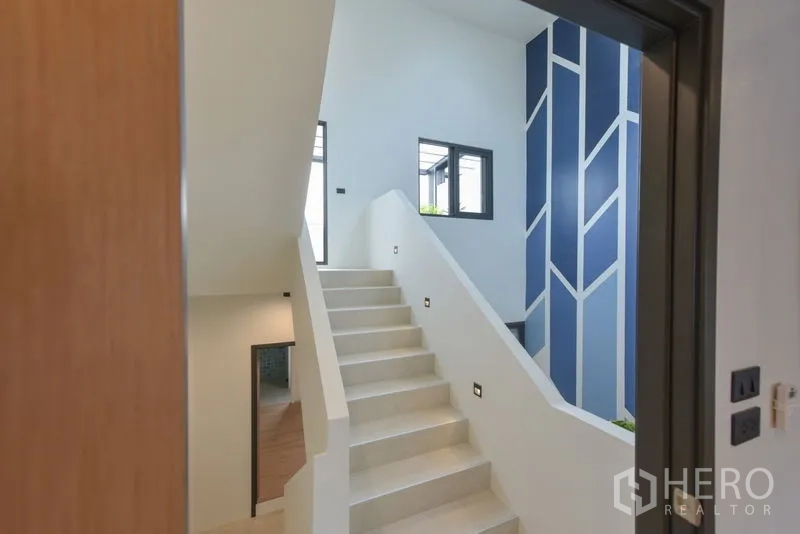 Home Office for rent or sale - Landing area leading to a white staircase and blue accent wall.