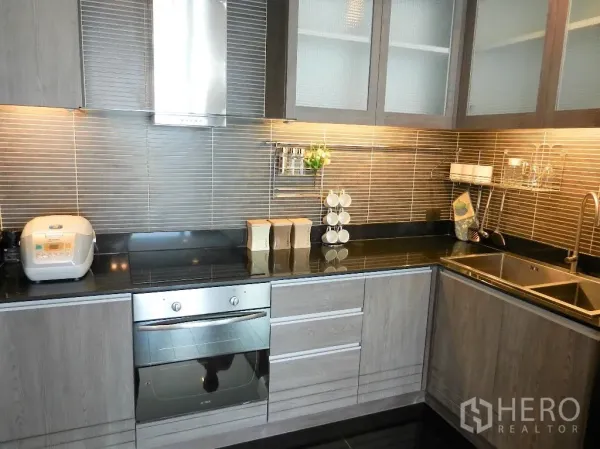 คอนโด ให้เช่าในWatthana, Bangkok - ครัวรูปตัวแอลสไตล์ร่วมสมัย ตู้ไม้ ท็อปหินแกรนิตสีดำ เตาอบบิลต์อิน และอ่างล้างจานคู่