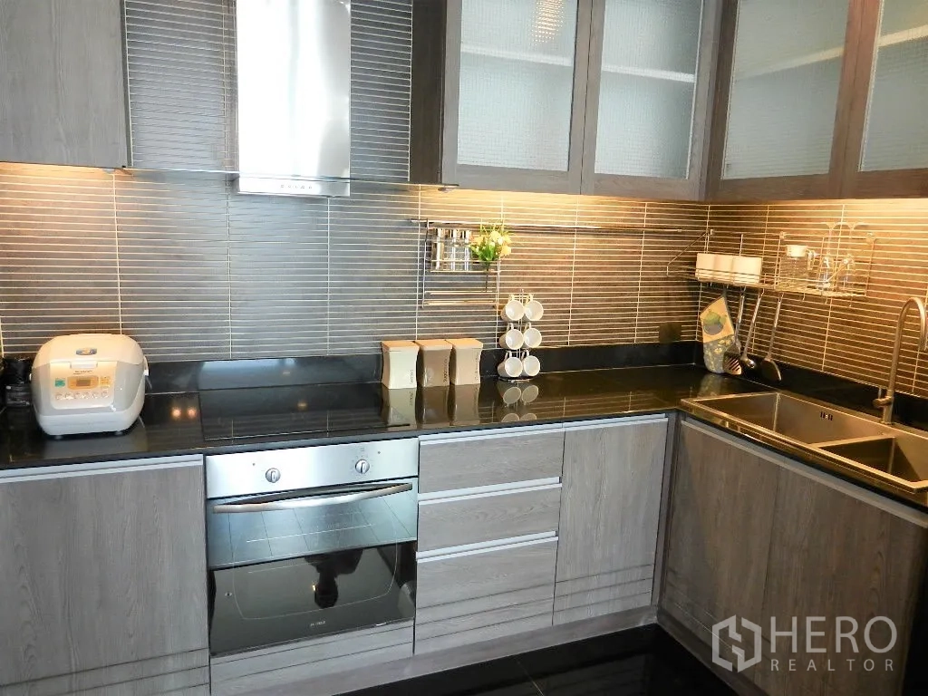 คอนโด ให้เช่าในWatthana, Bangkok - ครัวรูปตัวแอลสไตล์ร่วมสมัย ตู้ไม้ ท็อปหินแกรนิตสีดำ เตาอบบิลต์อิน และอ่างล้างจานคู่