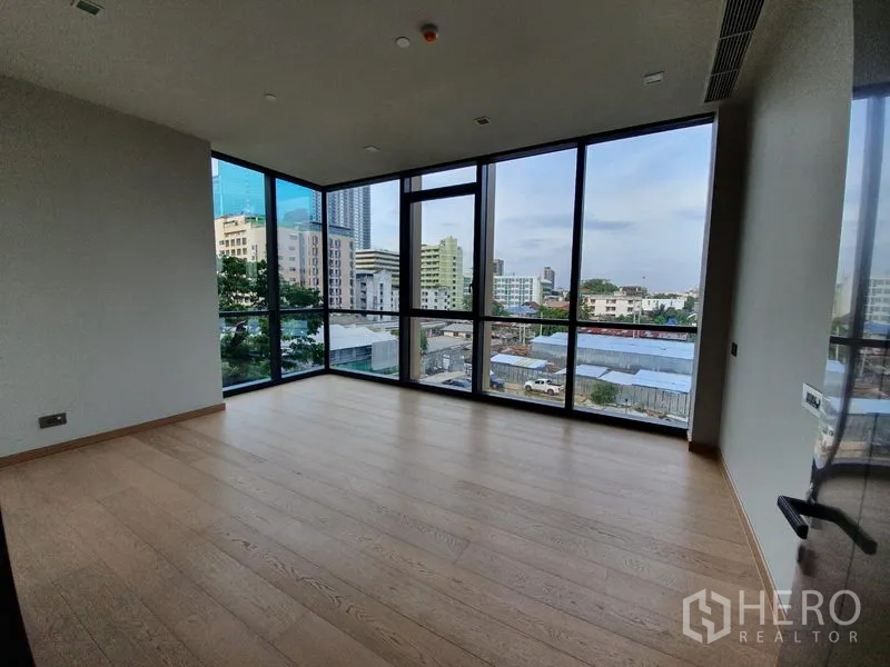 Condominium for rent in Watthana, Bangkok - Spacious corner bedroom with panoramic windows and skyline views over Watthana.