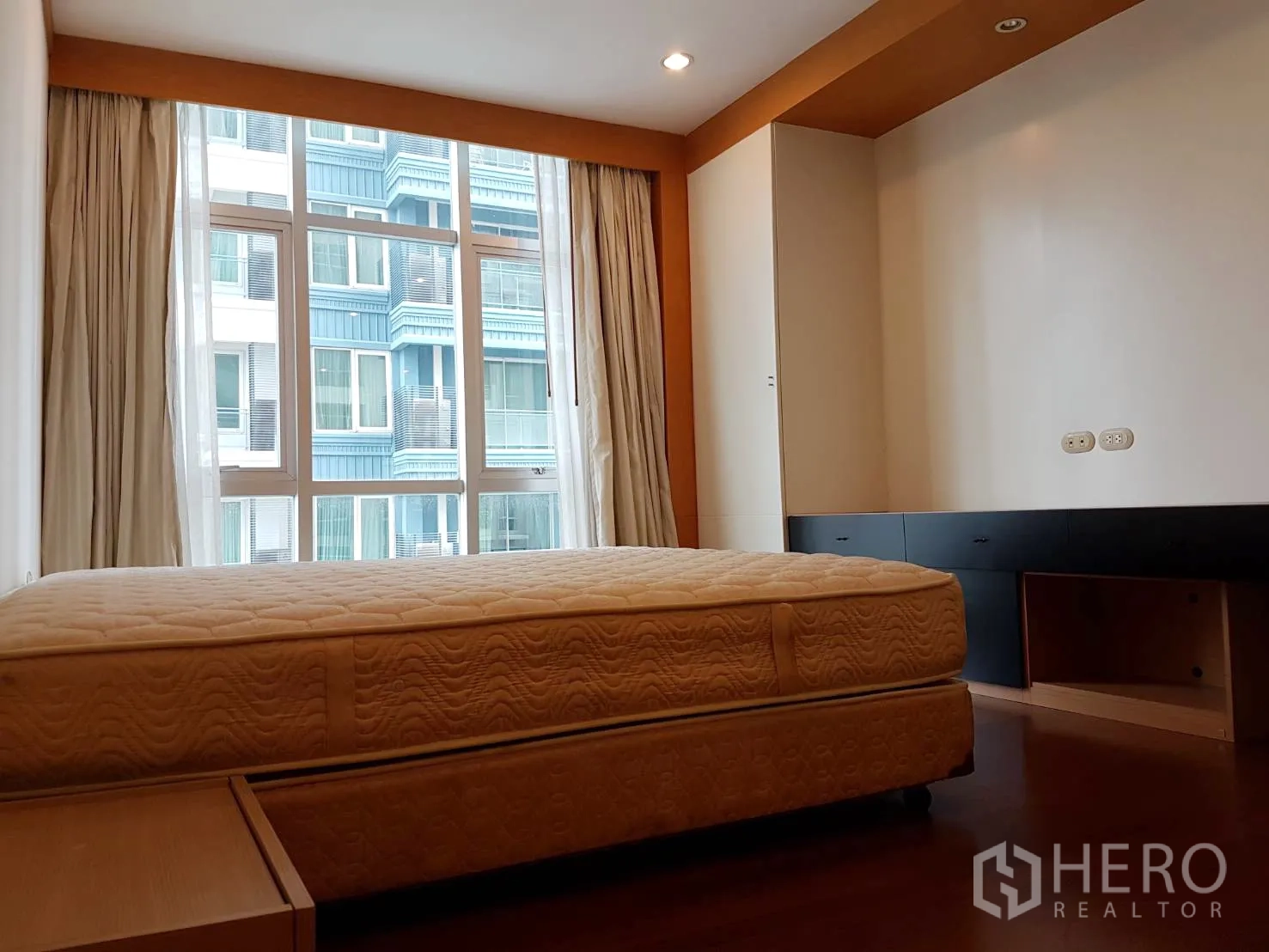 Condominium for rent in Pathum Wan, Bangkok - Primary bedroom with large window, built-in cabinetry and city view in a Pathum Wan condominium.