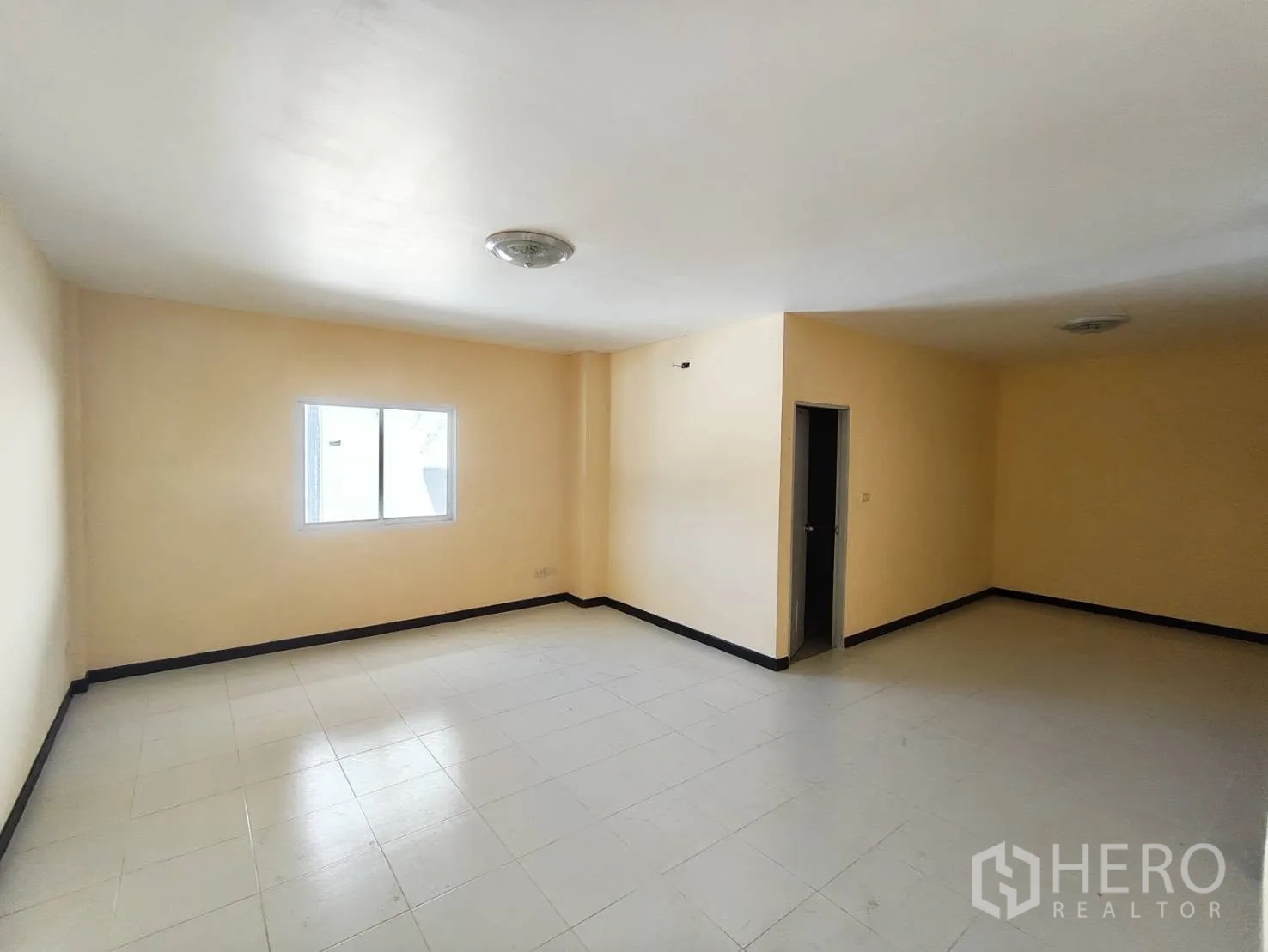 Factory for rent in Krathum Baen, Samut Sakhon - Large tiled room with a window and an internal doorway inside the residence.