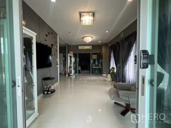 บ้าน ให้เช่าหรือขายในLat Krabang, Bangkok - มุมมองจากทางเข้าเข้าสู่ห้องนั่งเล่นโปร่งพื้นกระเบื้องสีขาว ผ้าม่านทึบสูง