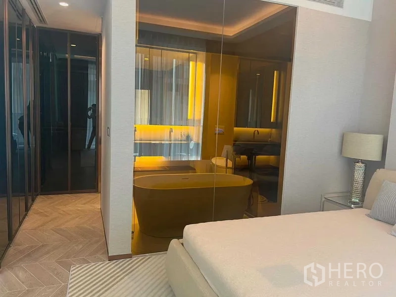 公寓 出租在Khlong Toei, Bangkok - 卧室与浴室玻璃相连，设独立浴缸与暖色灯光