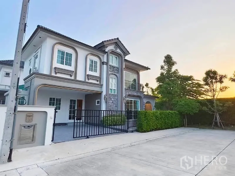 Detached House for rent in Bang Phli, Samut Prakan - Two-storey detached house with stone accents, balcony, front gate, and wide driveway.