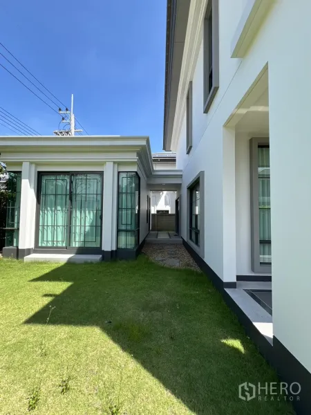 Detached House for rent or sale in Mueang Pathum Thani, Pathum Thani - Narrow lawn walkway between the main house and pavilion leading to a service area.