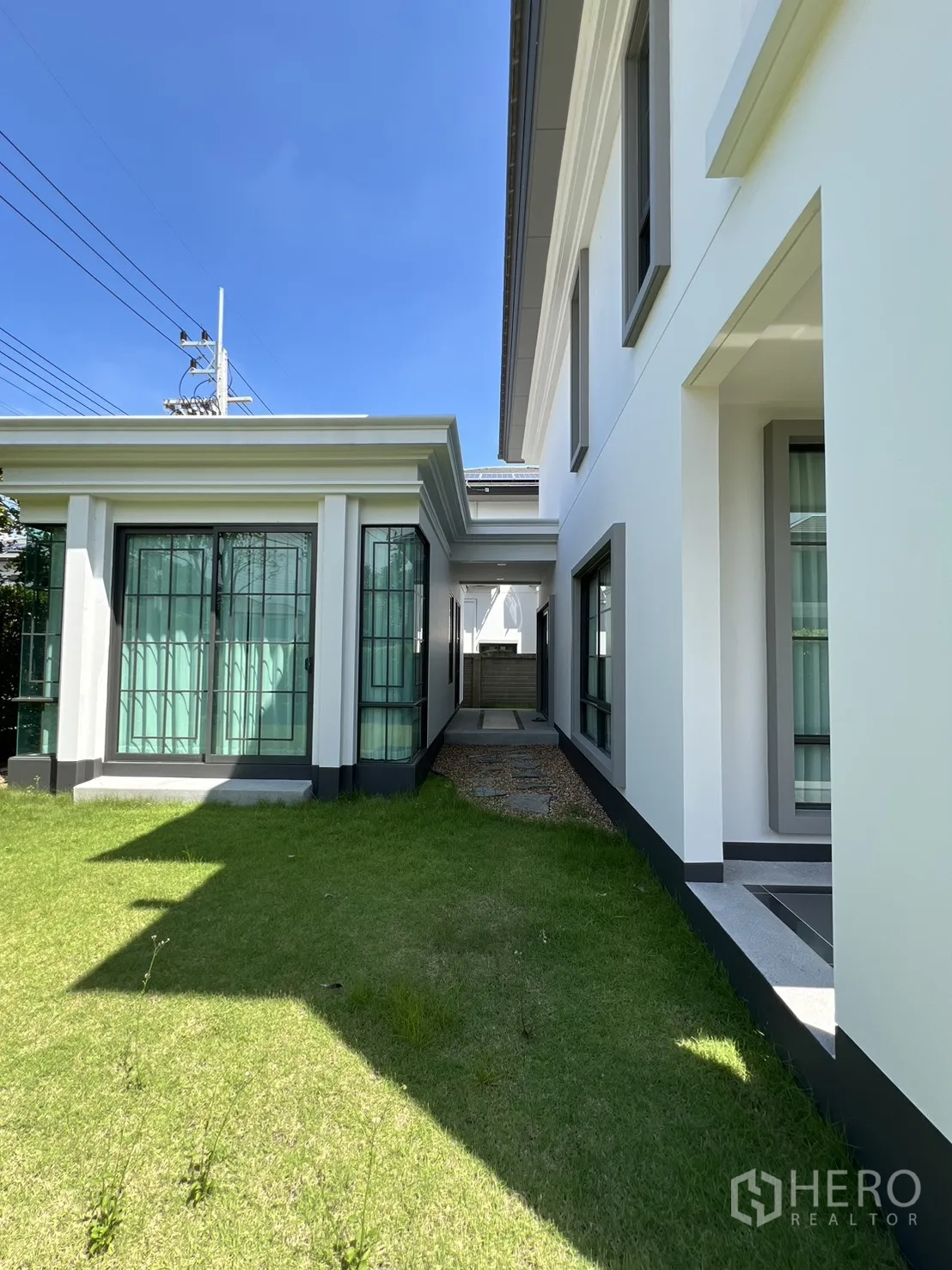 Detached House for rent or sale in Mueang Pathum Thani, Pathum Thani - Narrow lawn walkway between the main house and pavilion leading to a service area.