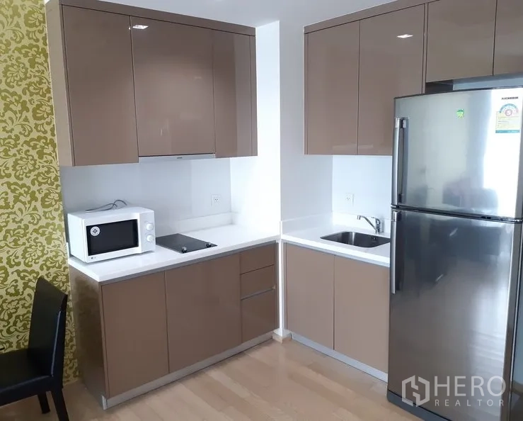 คอนโด ให้เช่าในKhlong Toei, Bangkok - ครัวมุมขนาดกะทัดรัด ตู้บิวท์อินเงา เตาไฟฟ้า ไมโครเวฟ และตู้เย็นสแตนเลส