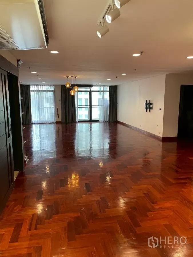 คอนโด ขายในWatthana, Bangkok - ห้องนั่งเล่นกว้าง พื้นไม้ลายก้างปลา เงางาม มีไฟดาวน์ไลท์และประตูกระจกออกระเบียง