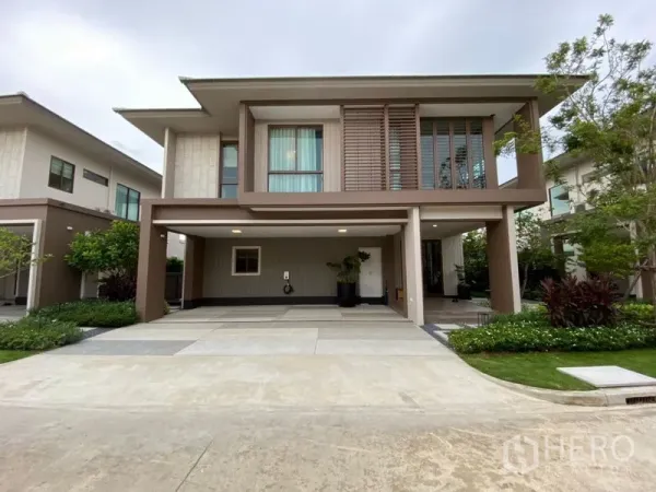 บ้าน ขายในBang Kapi, Bangkok - หน้าบ้านเดี่ยวสองชั้นสไตล์โมเดิร์น มีที่จอดรถในร่มสองคัน สวนตกแต่ง และหน้าต่างบานใหญ่ ในบางกะปิ