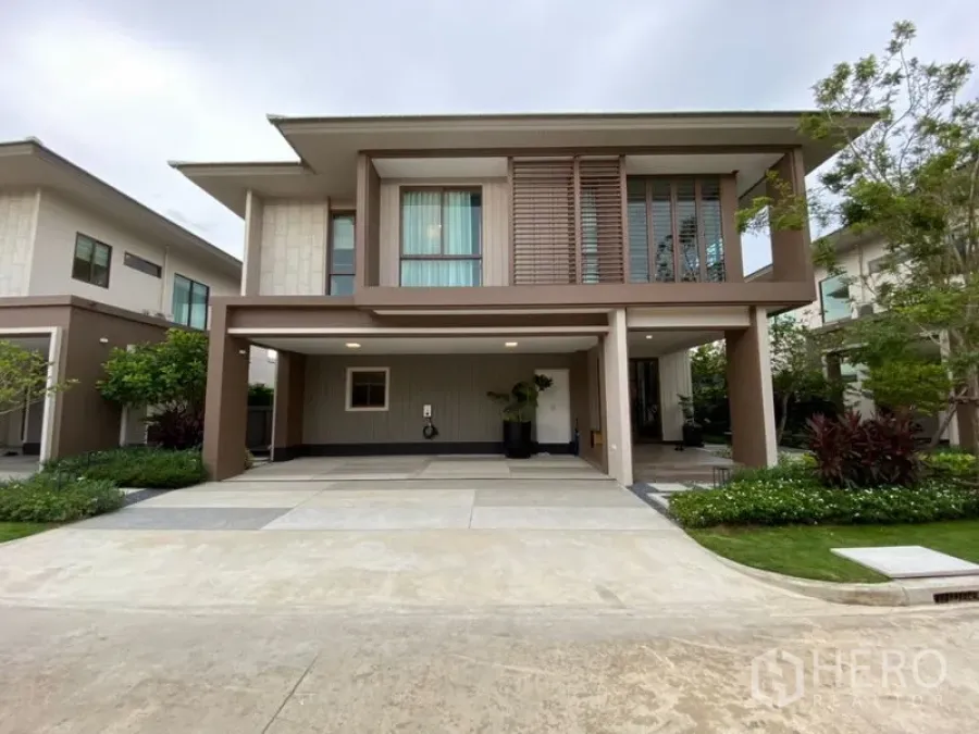 บ้าน ขายในBang Kapi, Bangkok - หน้าบ้านเดี่ยวสองชั้นสไตล์โมเดิร์น มีที่จอดรถในร่มสองคัน สวนตกแต่ง และหน้าต่างบานใหญ่ ในบางกะปิ