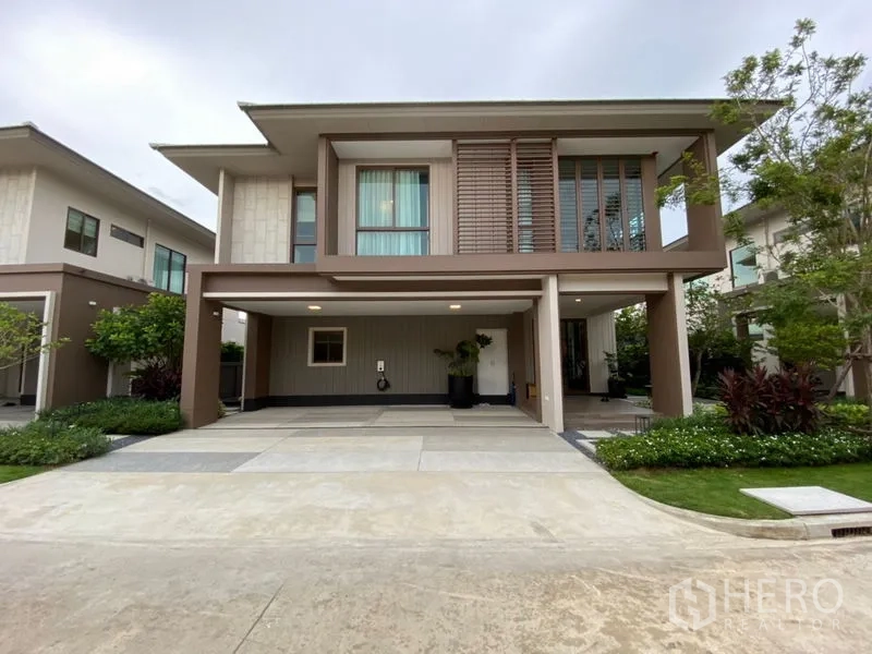 บ้าน ขายในBang Kapi, Bangkok - หน้าบ้านเดี่ยวสองชั้นสไตล์โมเดิร์น มีที่จอดรถในร่มสองคัน สวนตกแต่ง และหน้าต่างบานใหญ่ ในบางกะปิ